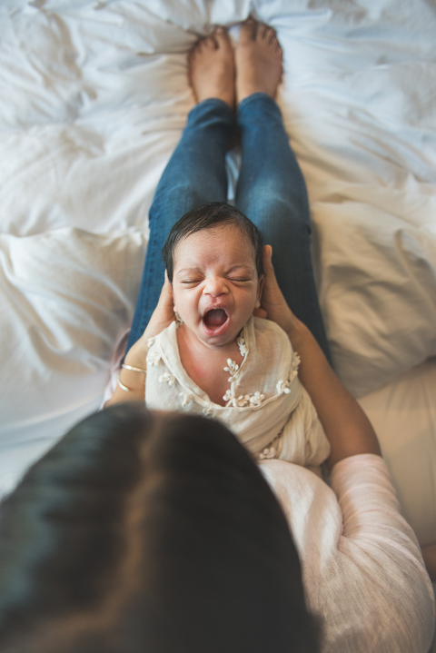 Baby girl yawning on moms lap