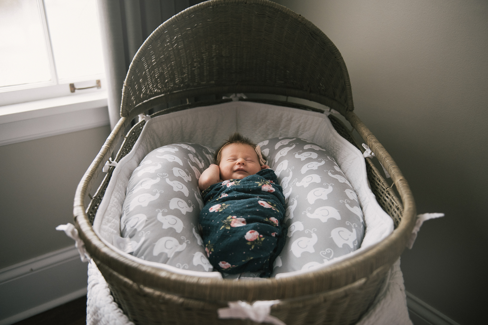 Baby in flower wrap inside bassinet