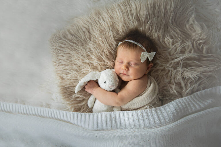 newborn holding stuffed bunny portrait